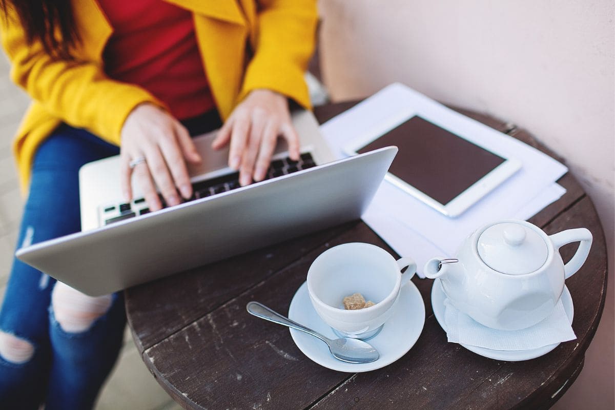 A freelancer working a gig job from a laptop at a cafe.