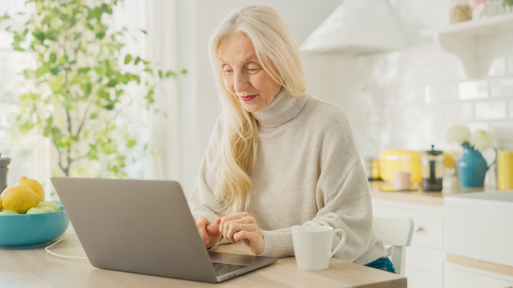 A female retiree earning extra money from home on laptop