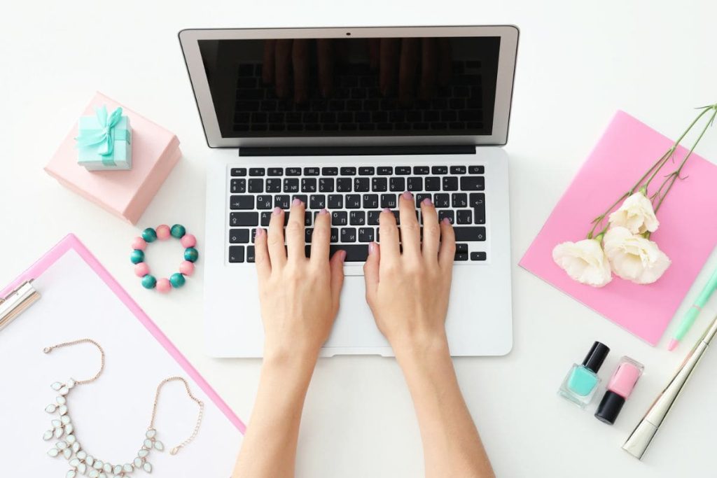 A closeup of a woman typing on a laptop computer.