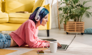 Female freelancer working her virtual jobs listening to music on her headphones while typing