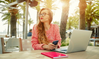 Young girl working on her laptop near the beach