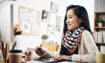 A graphic designer working from home using a desktop computer and drawing tablet to create SVGs.