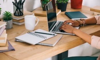 Woman writing resignation letter on laptop.