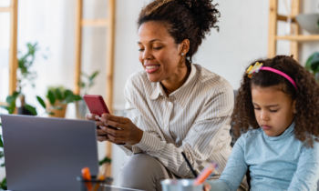 Mother working her stay-at-home mom job sitting next to her daughter