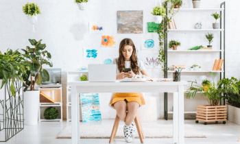 Young girl working in a home office with a lot of paintings