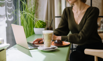 Small business owner using her laptop drinking a latte in a cafe