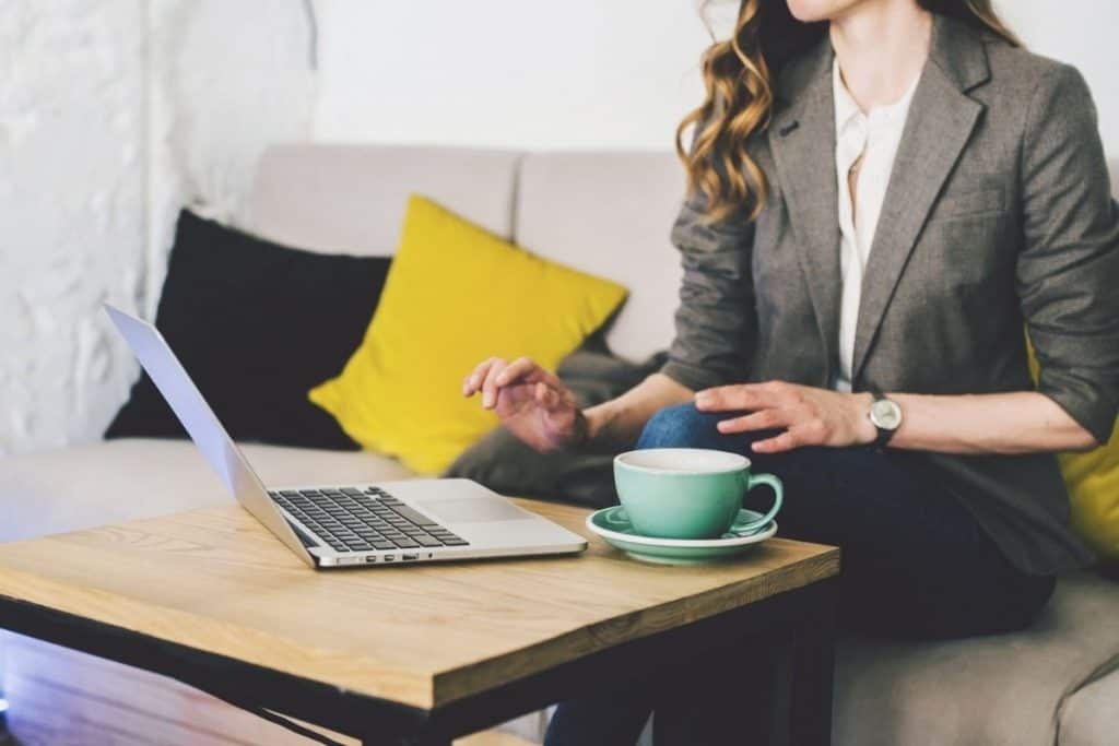 Woman working from home on a laptop, drinking coffee