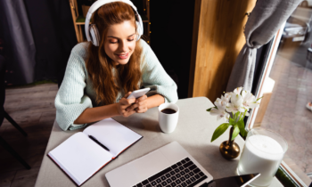 Woman wearing headphones reading an Appen review on her smartphone