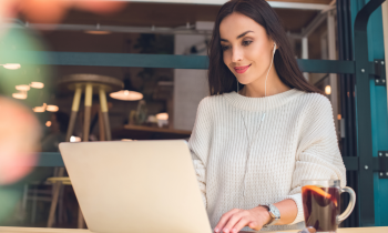 woman working from home on laptop drinking tea