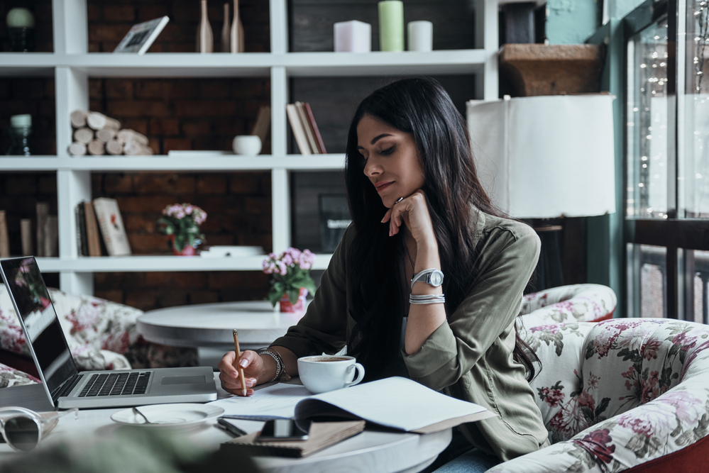 Woman writing in a notebook finding a career path that is perfect for her