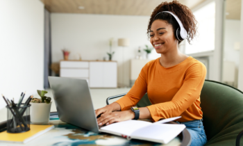 Young black woman using laptop at home for her typing jobs