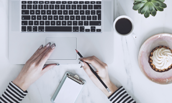 woman working from home at her desk eating breaking before starting her marketing job